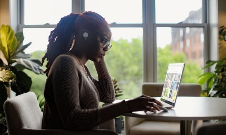 woman on laptop on pc by a window