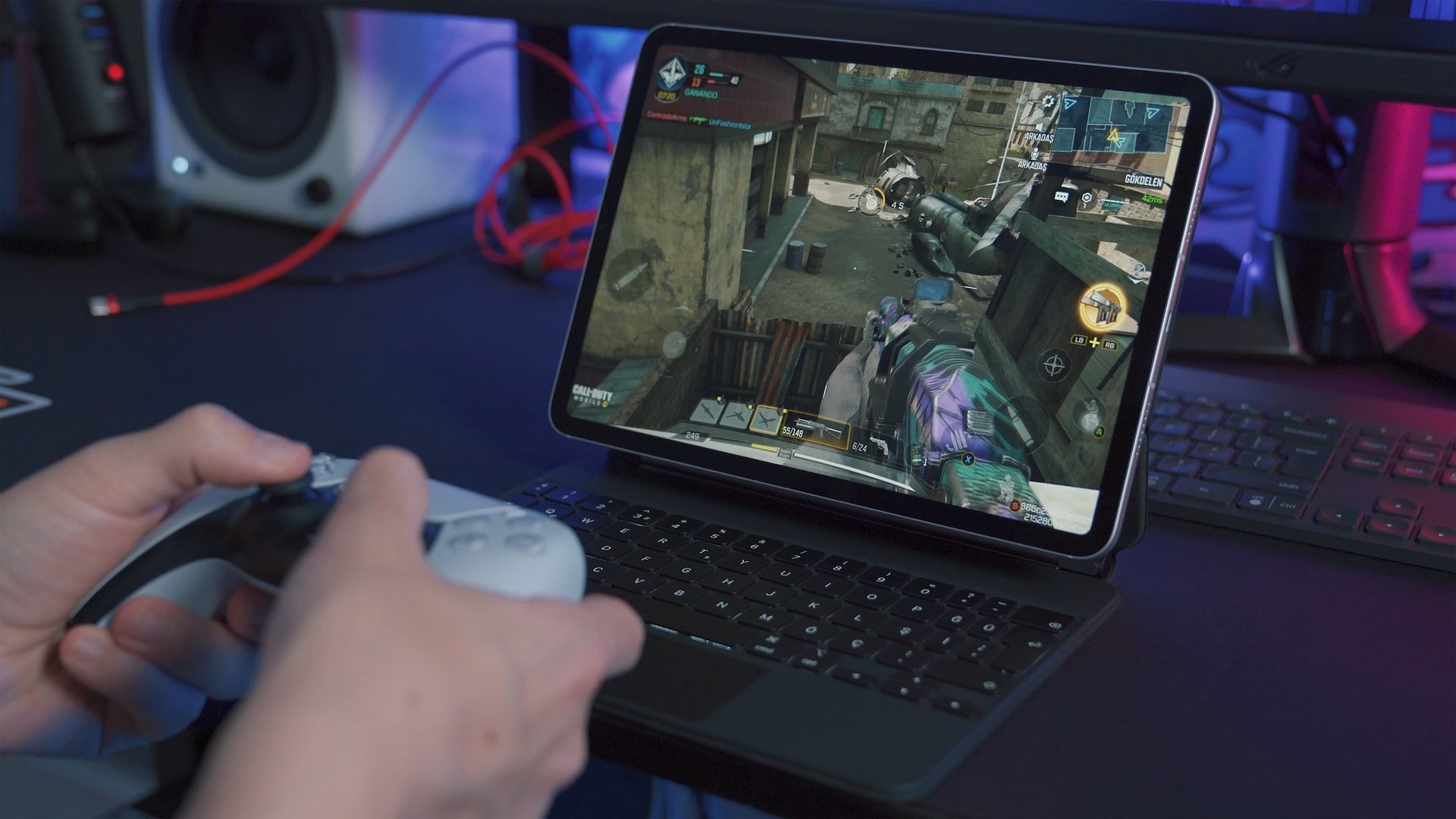Person gaming on a tablet, using a controller.
