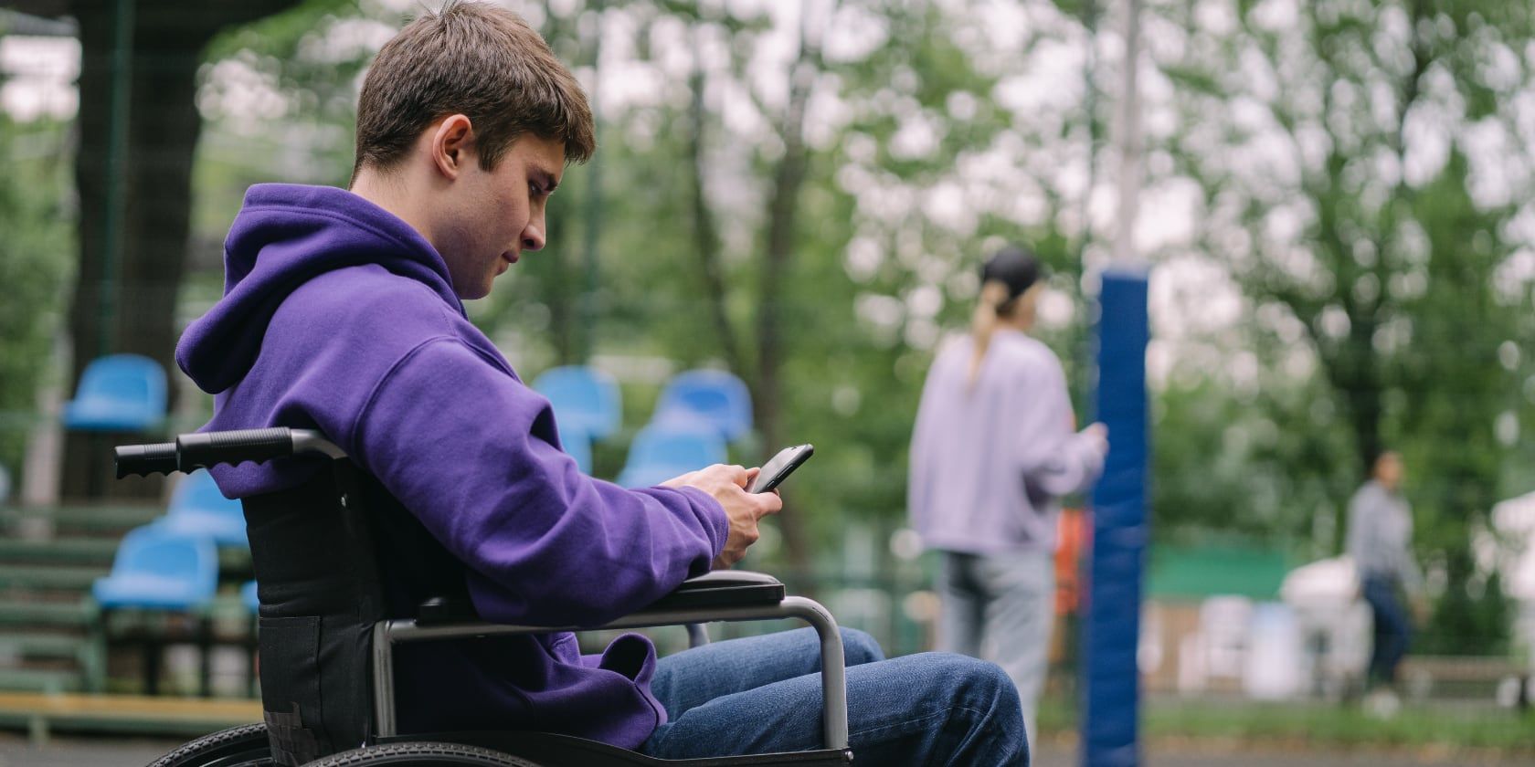 man in wheelchair using phone