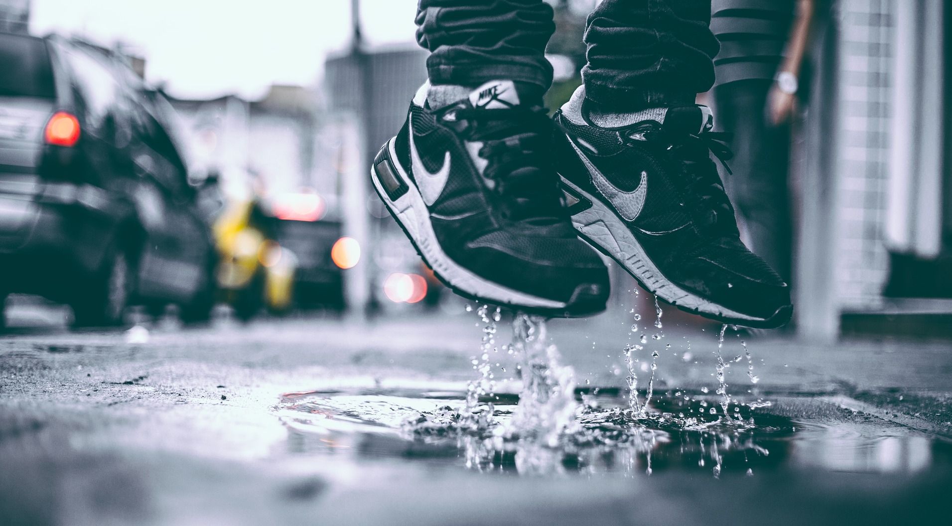 black nike sneakers in puddle