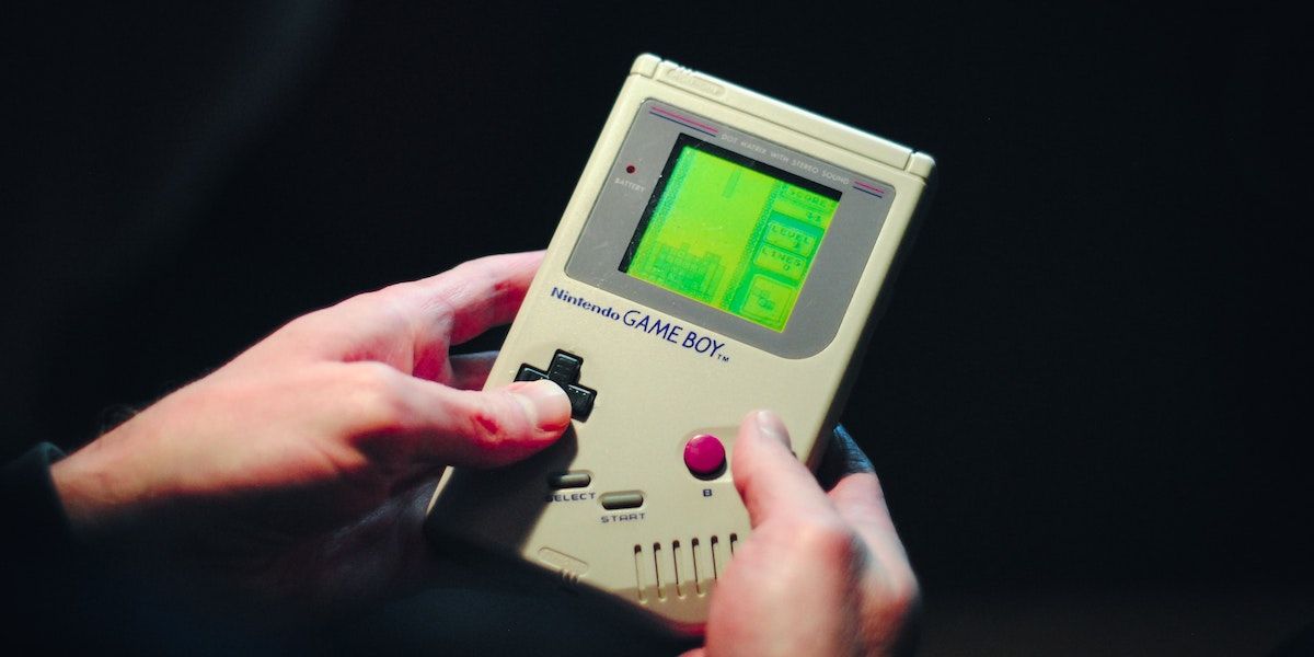 A person playing a Game Boy