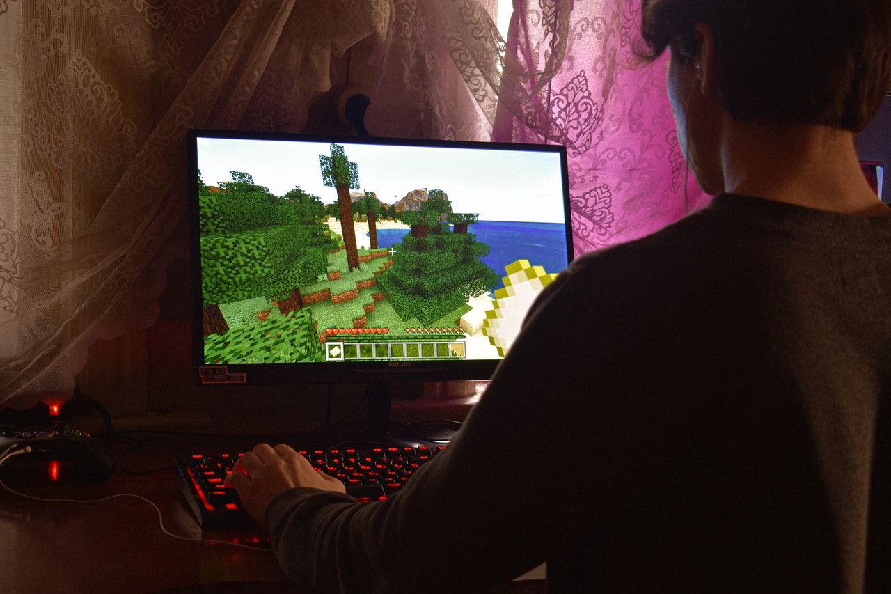 Person playing Minecraft on a gaming computer.