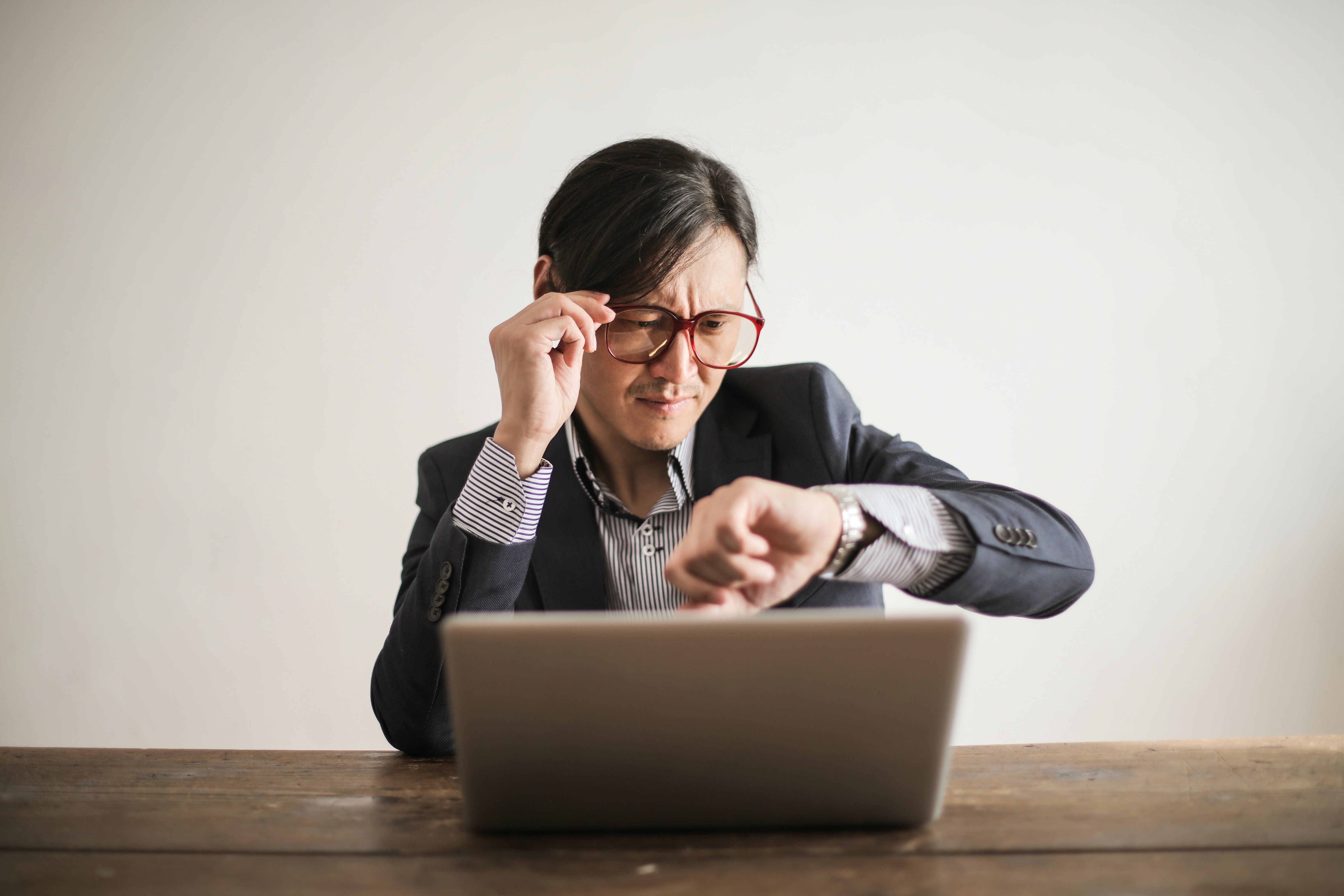 Person sitting on his desk and watching time