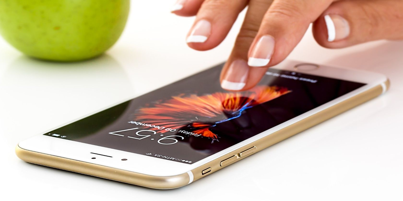Woman's finger tapping iphone screen on white table