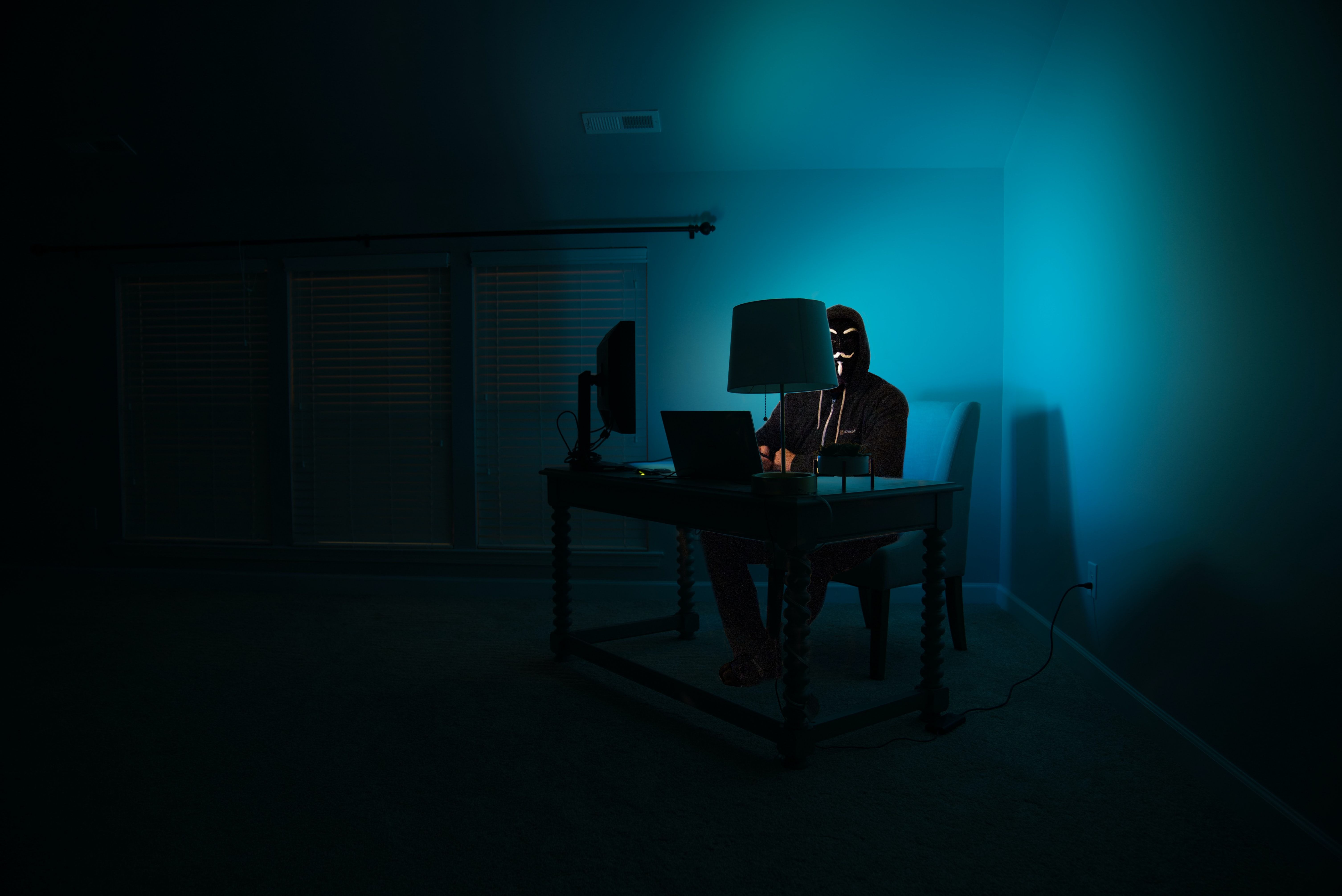 Photo of a hacker sitting at a computer 