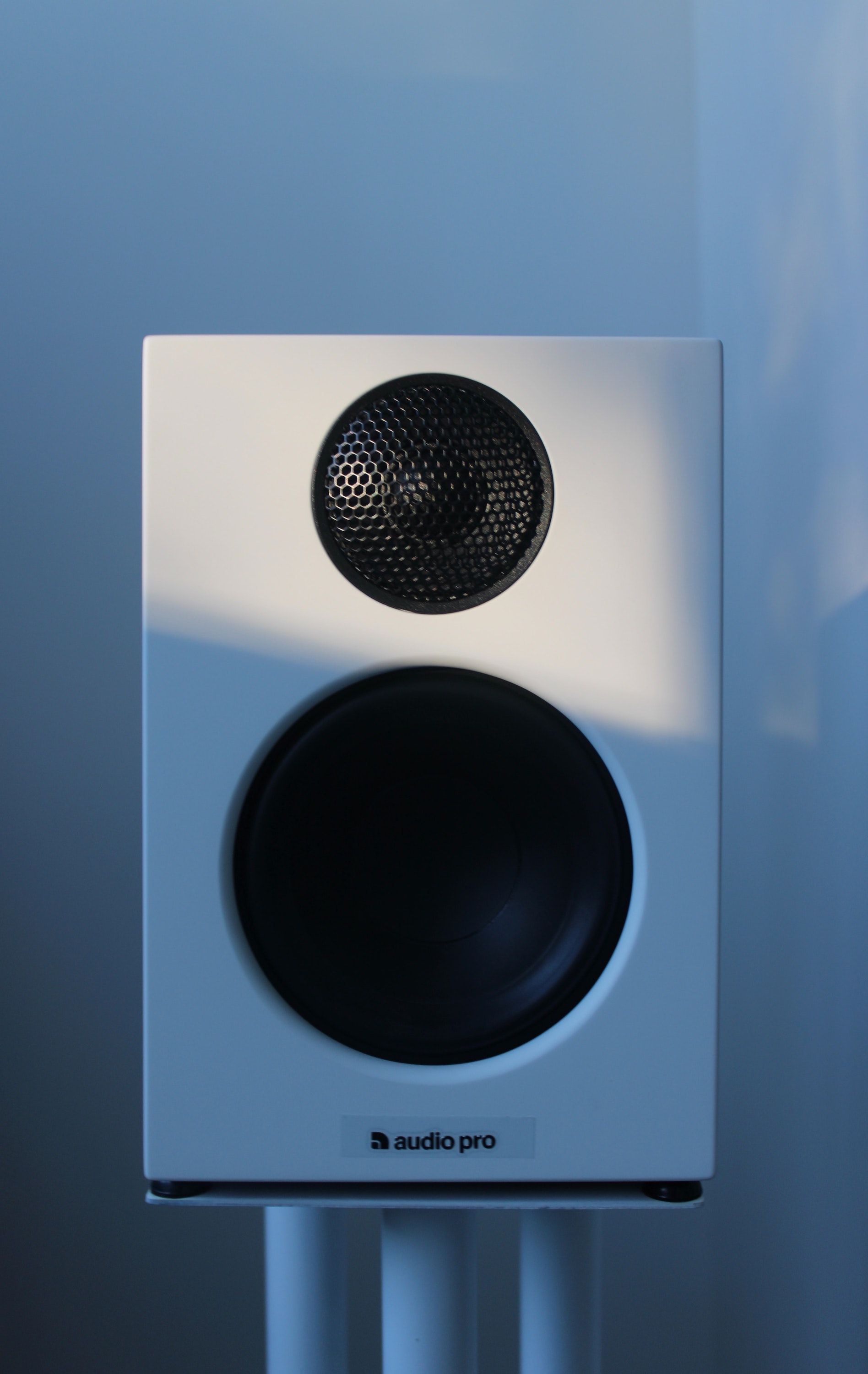 A photo of a white monitor on a floor speaker stand