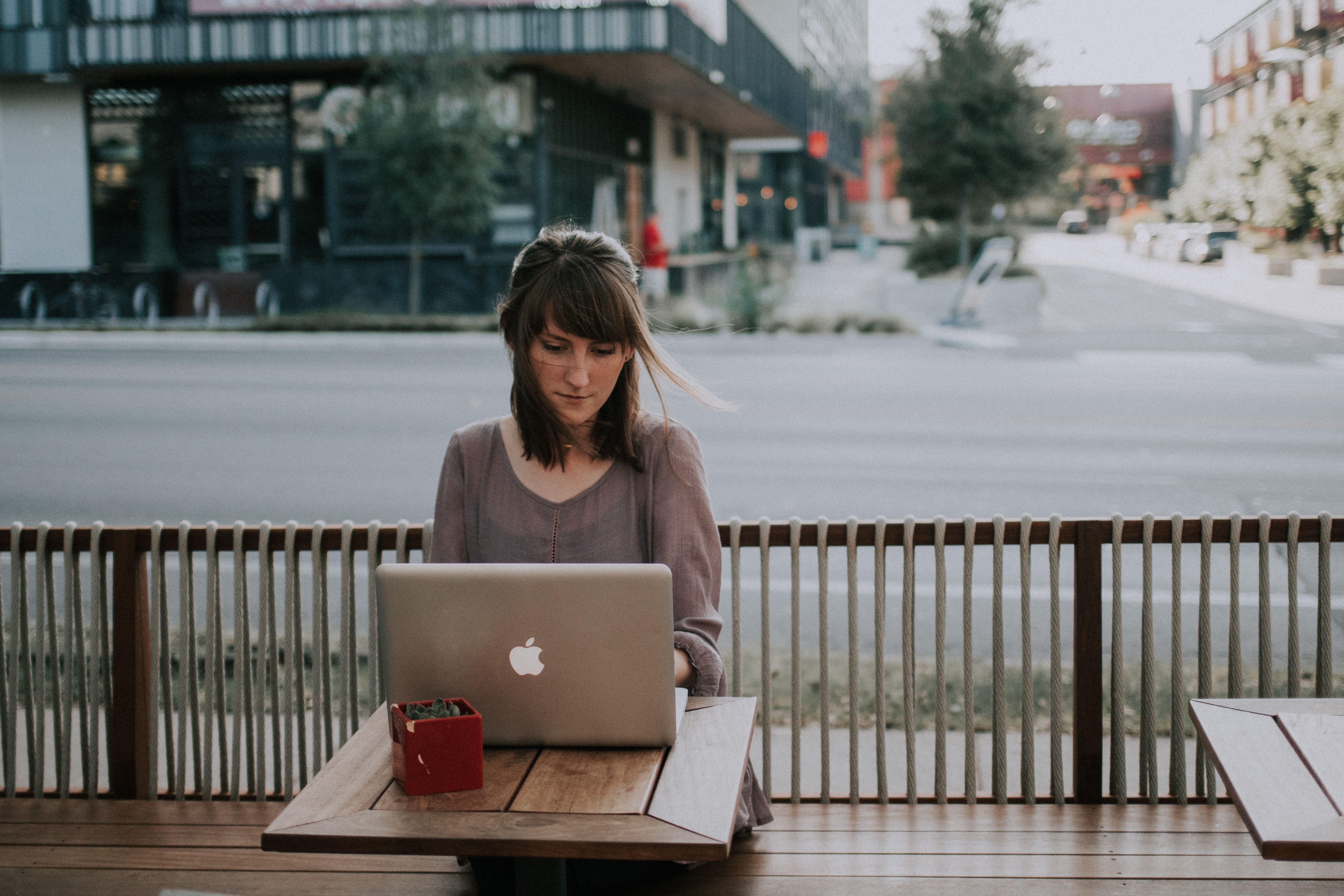 Photo of a person working from their laptop outdoors 
