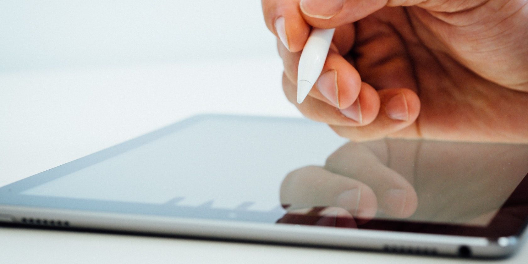 A person writing with their Apple Pencil on an iPad. Image from Unsplash. No attribution is needed.
