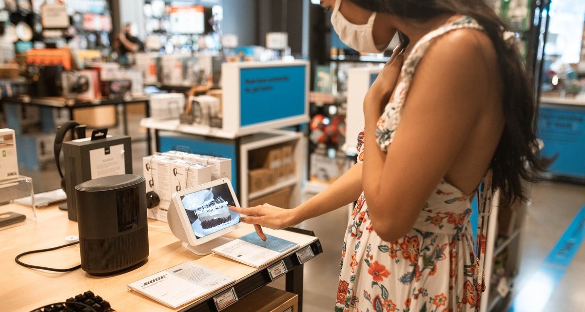 woman touching tablet in electronics store