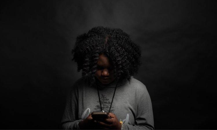girl looking at phone with gray background