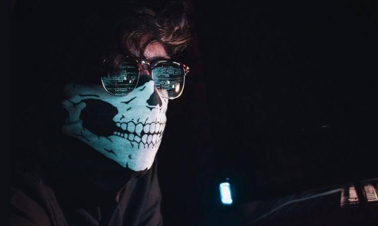 hacker on computer in mask and glasses