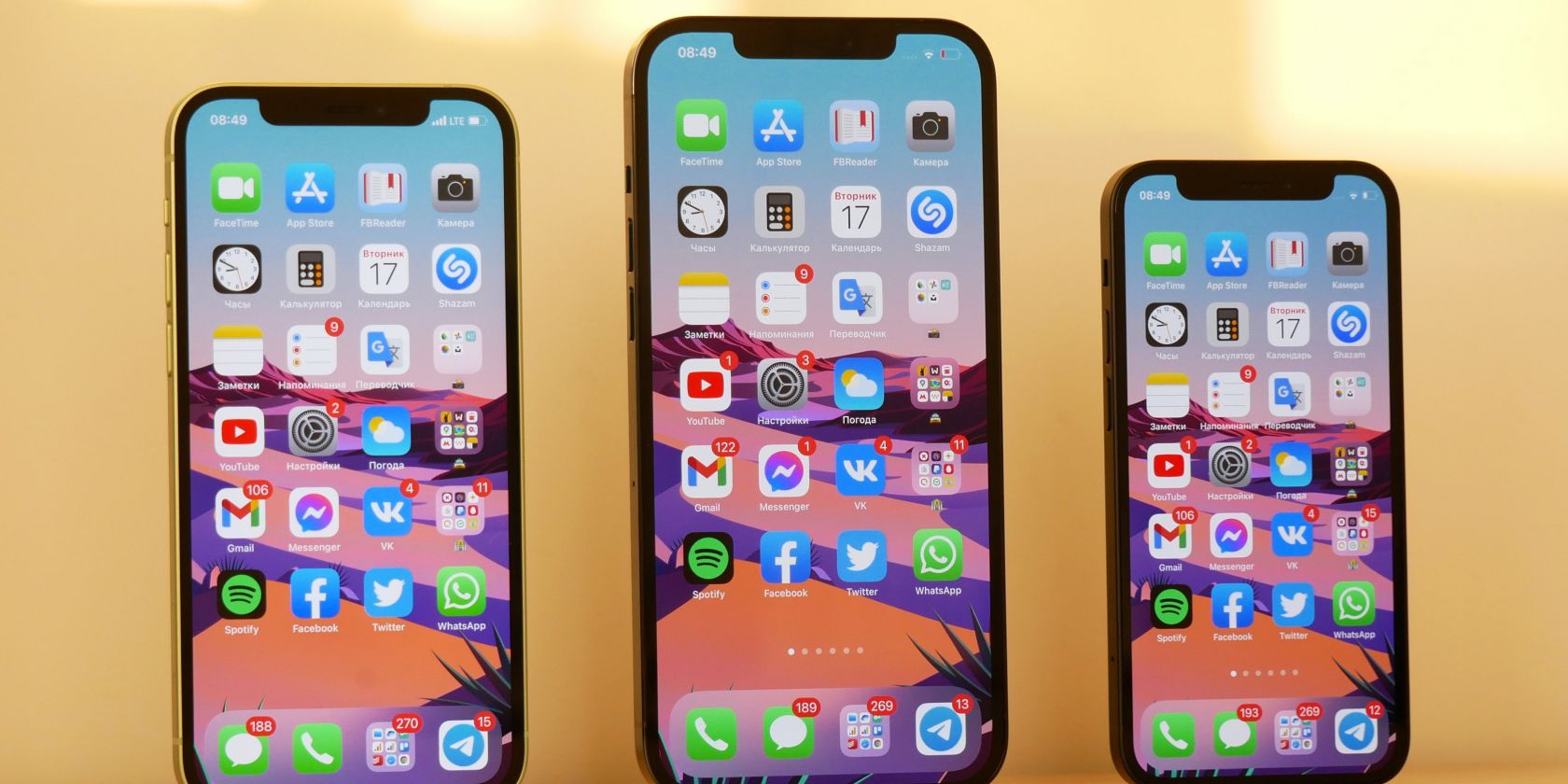 Photo of three phones with identical home screens stood next to each other