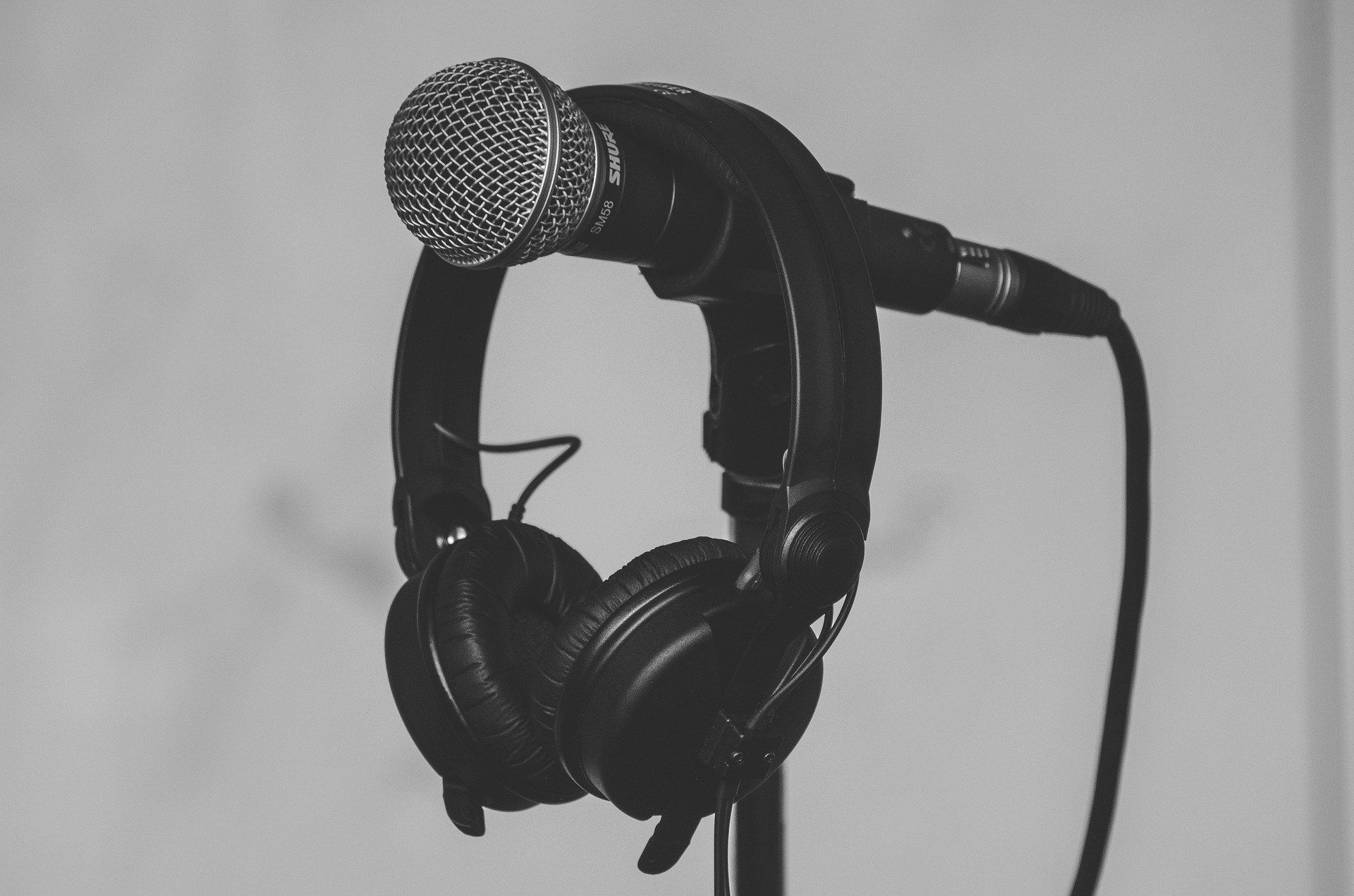 black headphones hanging on microphone stand
