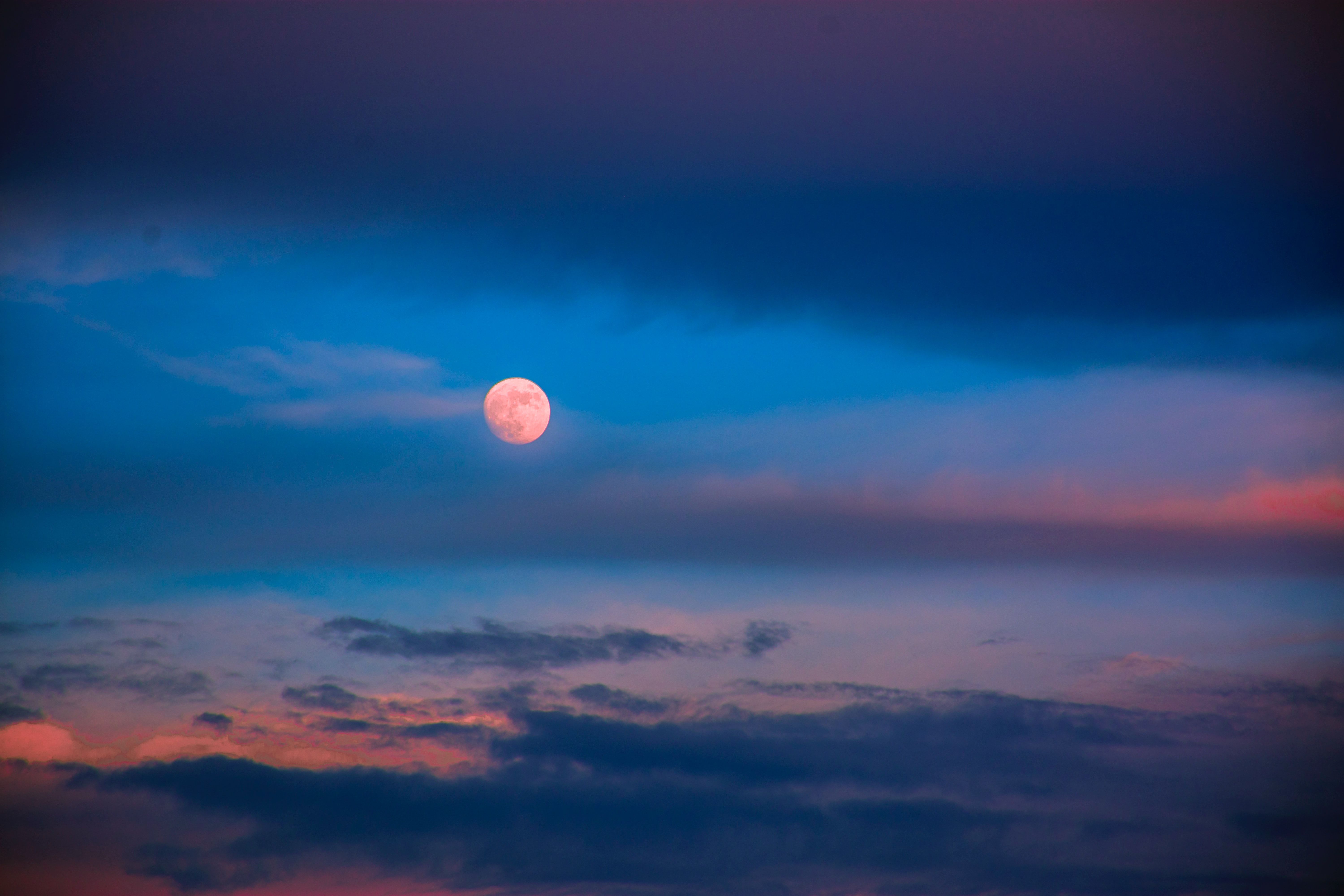 almost-full moon in a cloudy sky