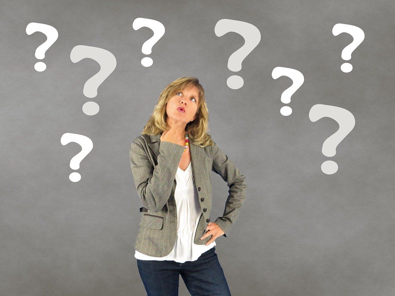 Person standing with a ponderous expression, surrounded by question marks