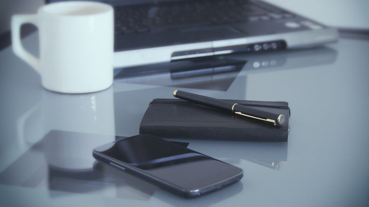 Photograph of Phone and Laptop on Desk