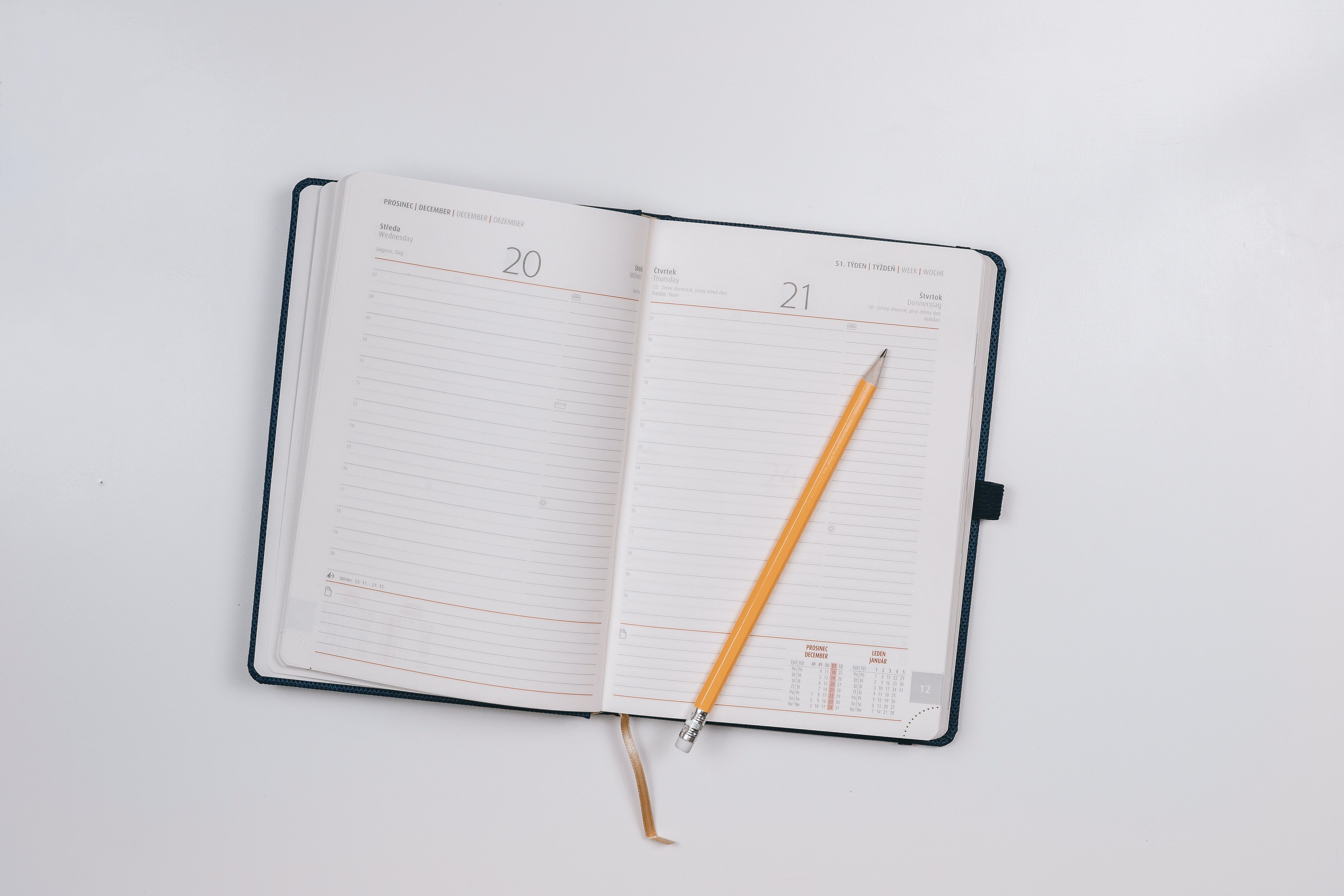 A planner open with a pencil on it