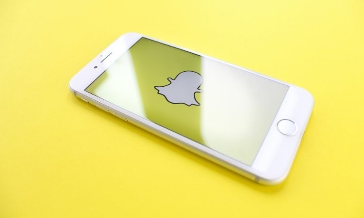 snapchat logo against yellow background on phone