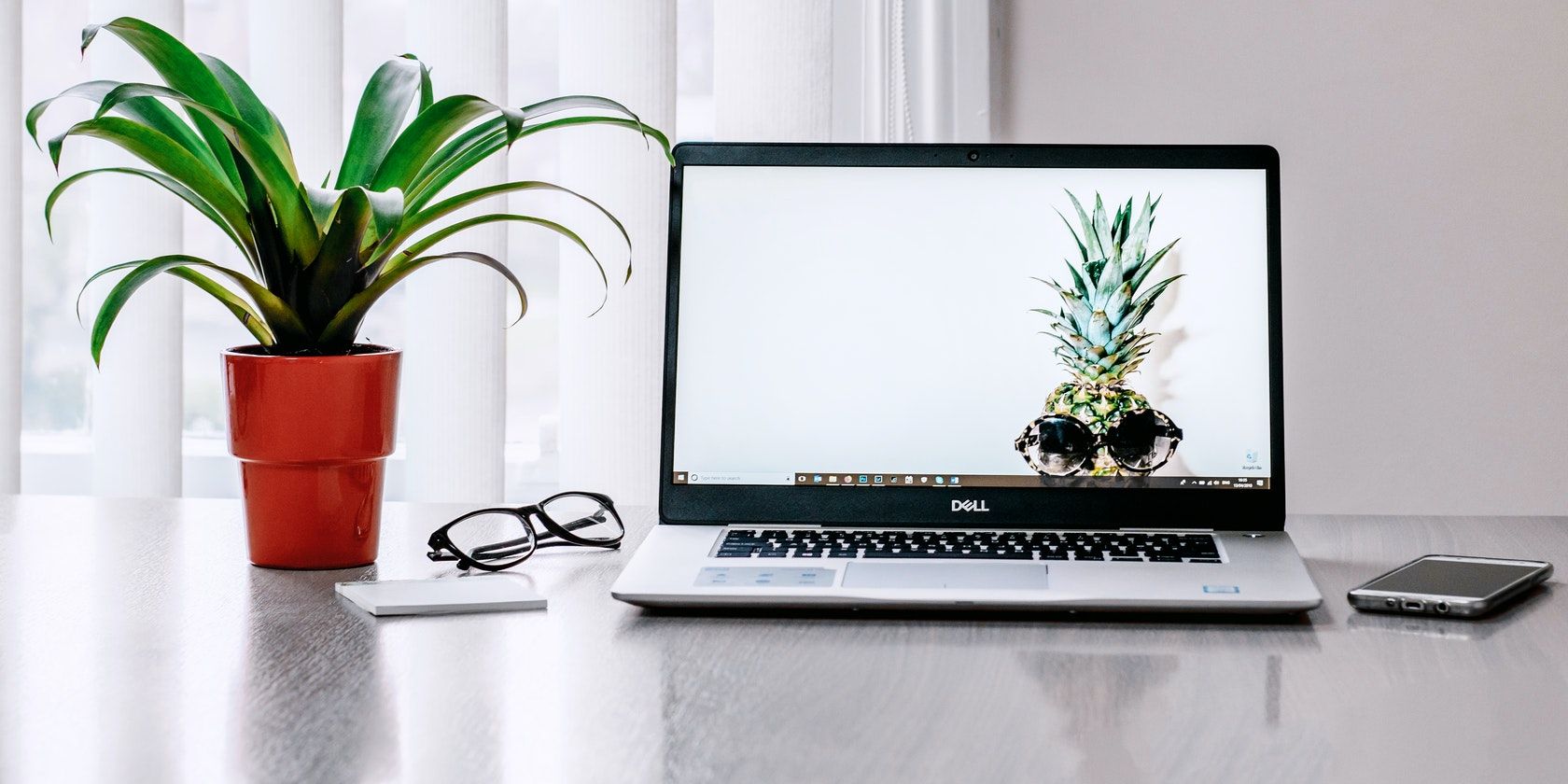 Laptop Placed Near a Plant on Table 