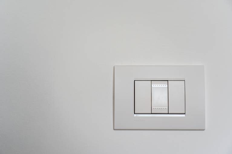 Cara Menghemat Energi di Rumah Foto saklar lampu di dinding