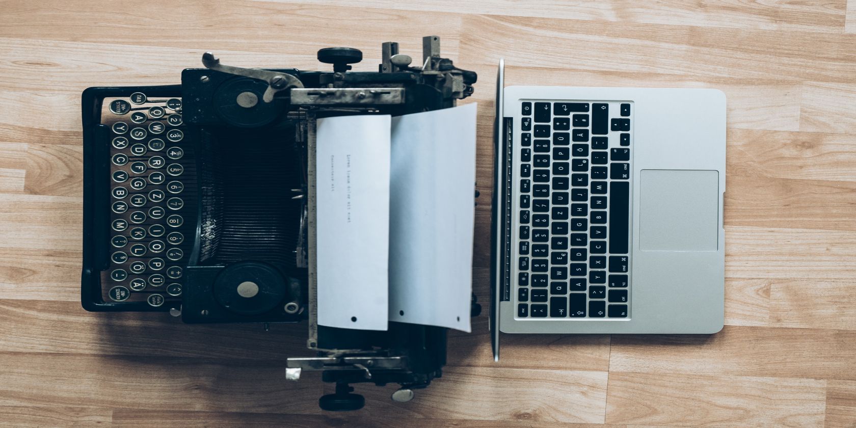 Image shows a typewriter next to a MacBook