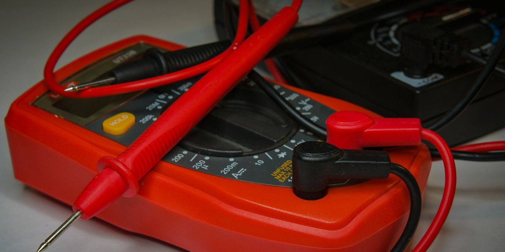 Multimeter Placed on a Table With Test Leads Inserted in Plugs