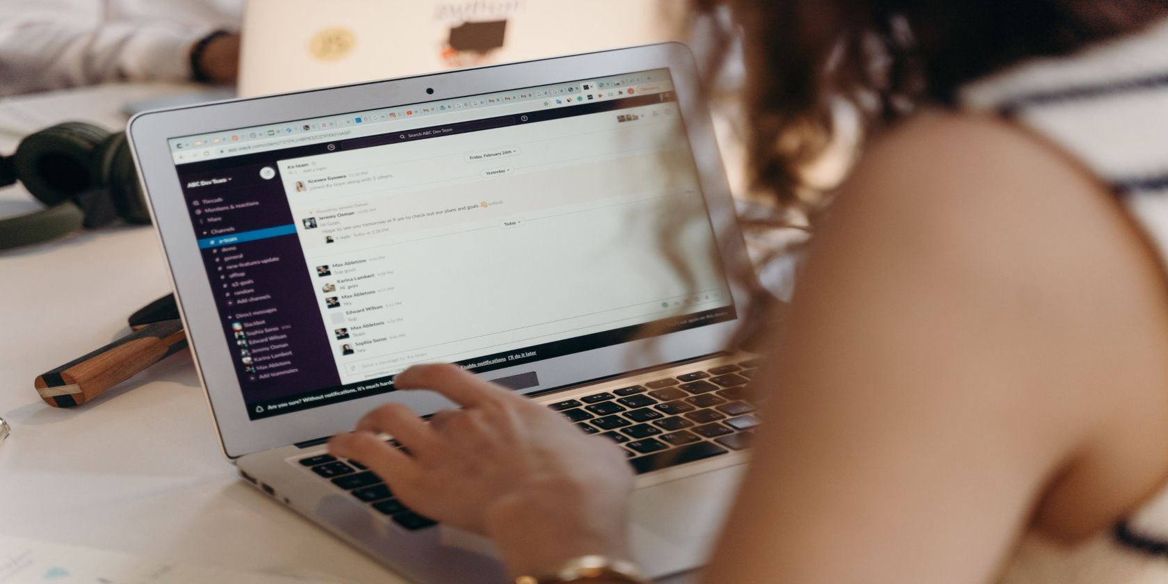 Image shows a women using Slack on a MacBook