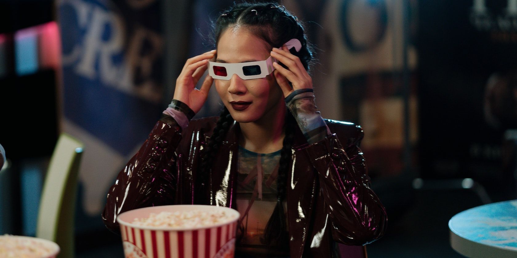Woman in leather jacket holding 3D glasses in the cinema