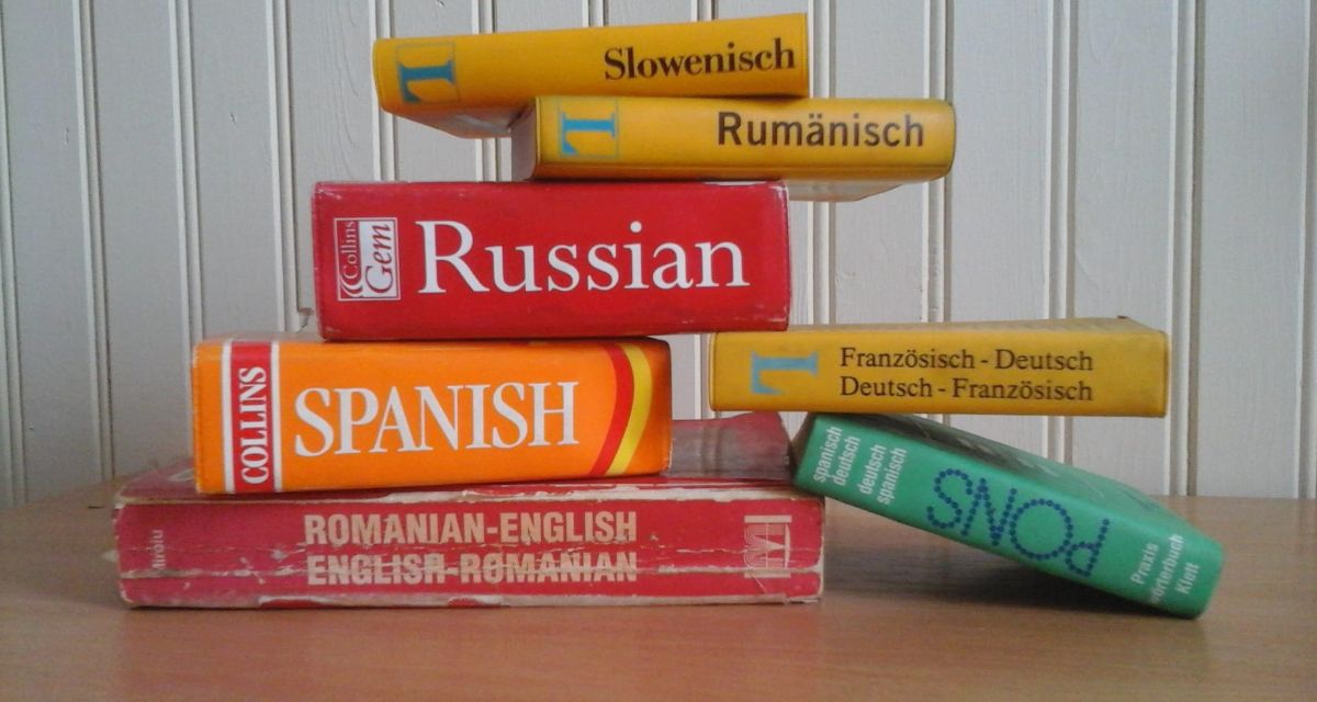 assorted language books stacked on top of each other