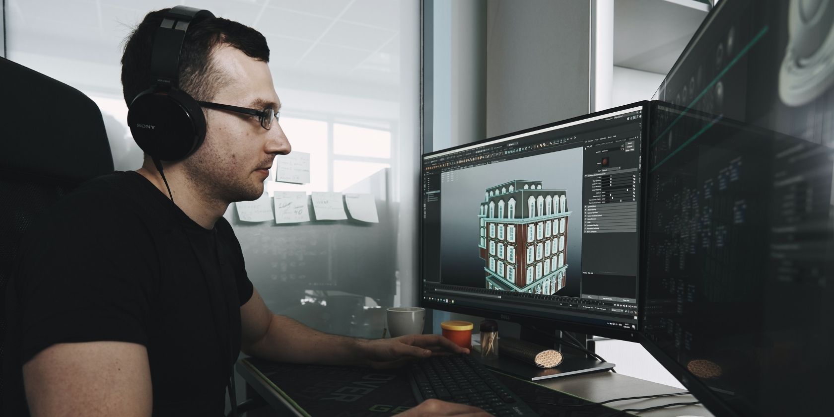 Man in black tank top wearing black glasses using a computer