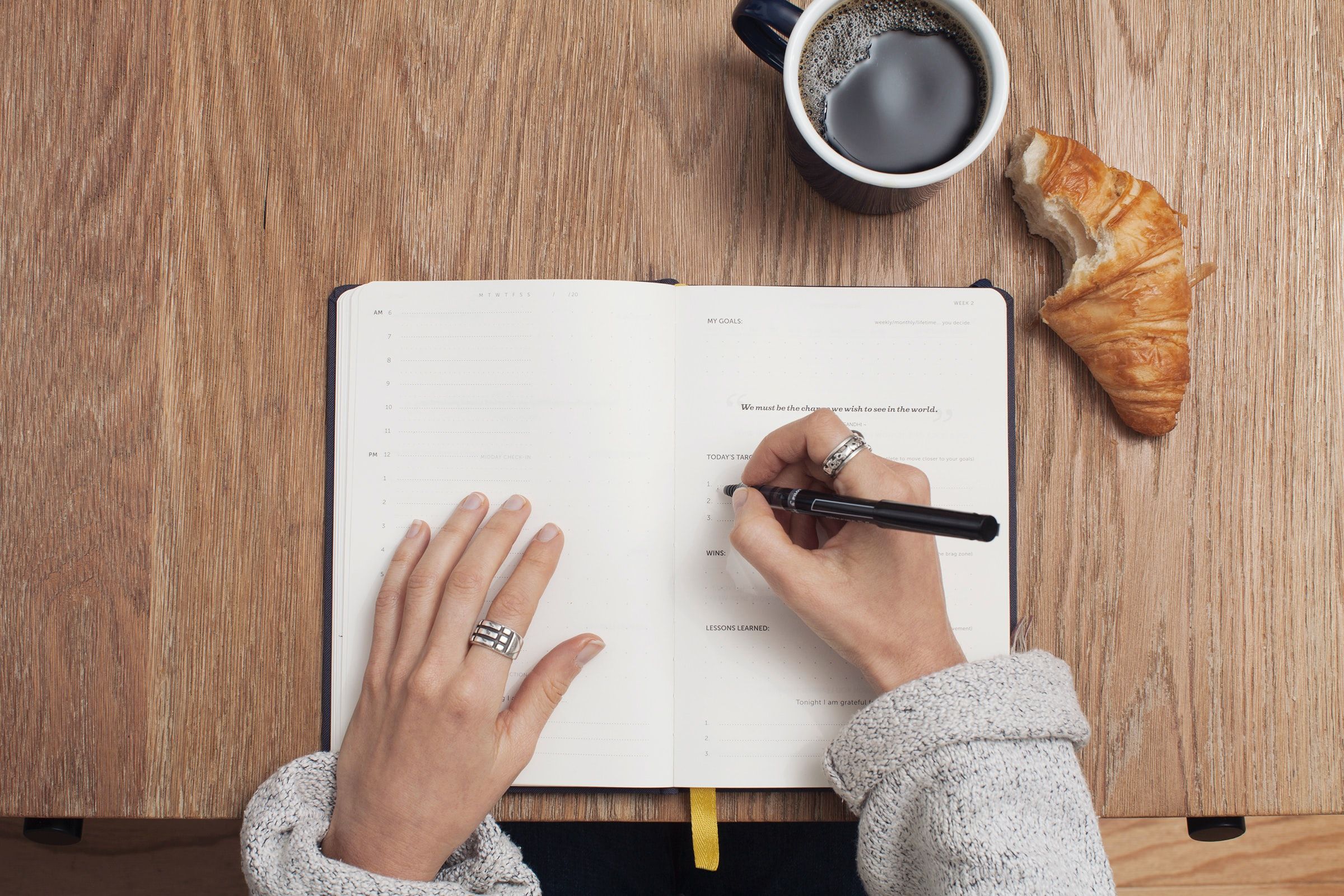 A woman journaling with a pastry.