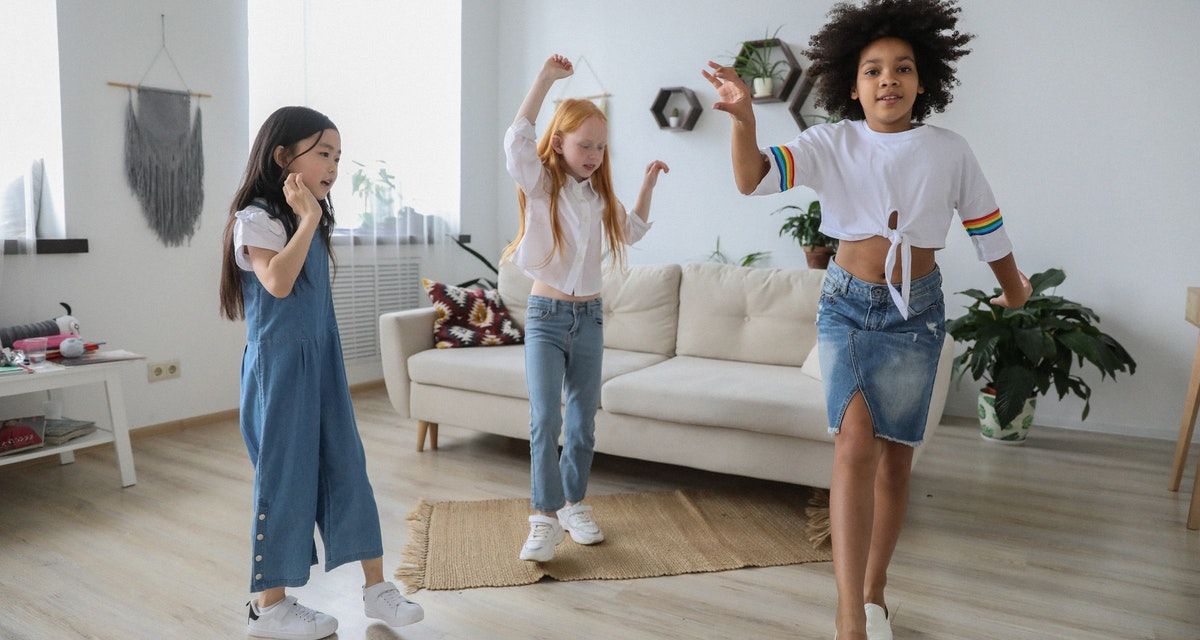 three girls dancing in living room