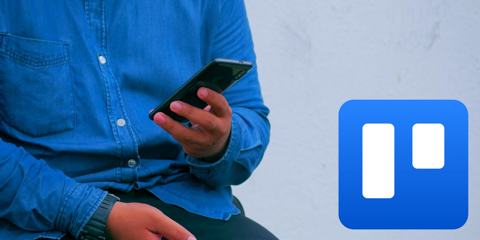 Person wearing a denim jacket holding a phone, with the Trello app icon to the right.