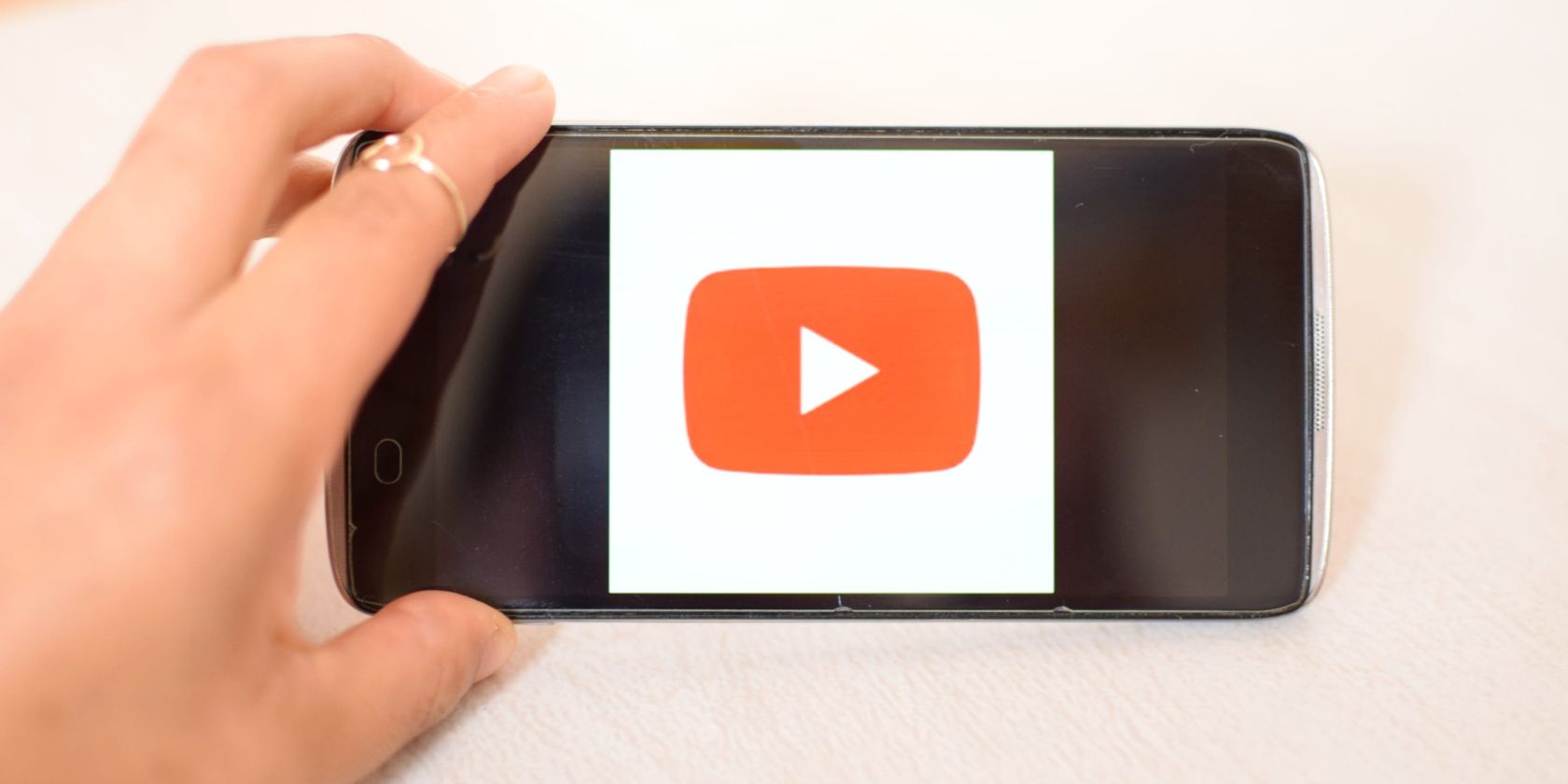 hand holding phone with youtube logo