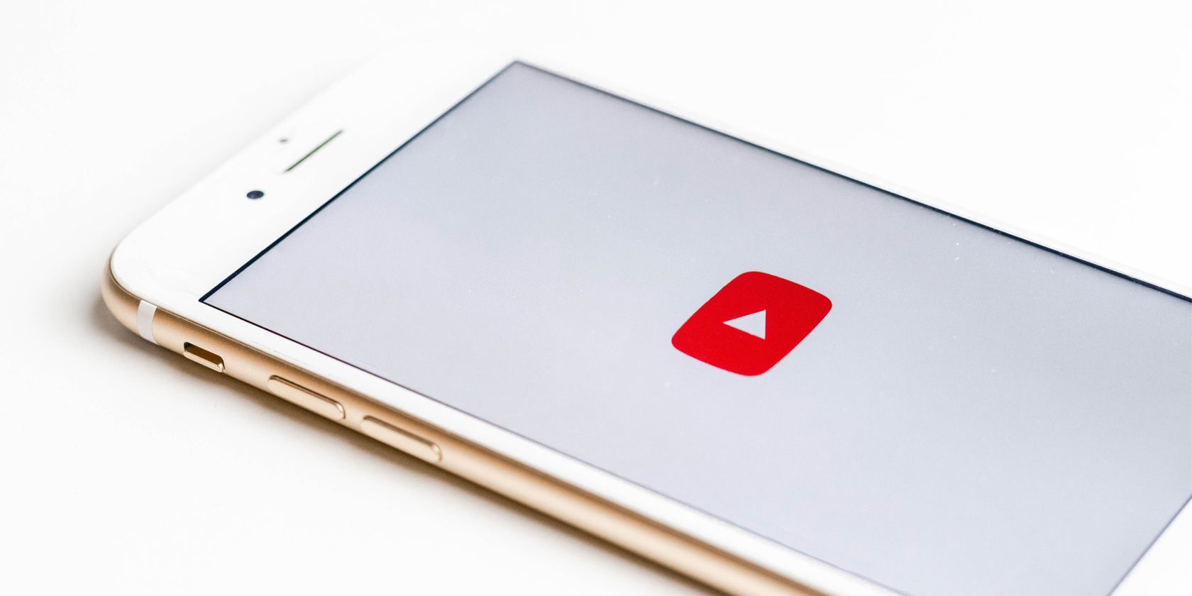 iPhone on white surface, showing YouTube logo