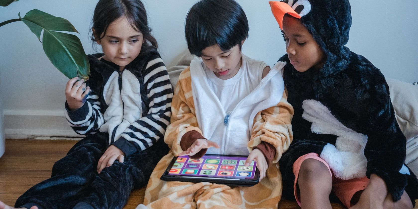 three kids playing with tablet