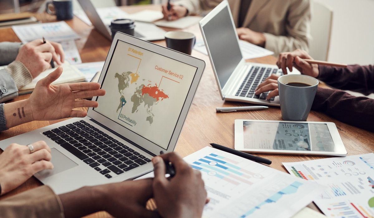 People's hands with laptops and pieces of paper