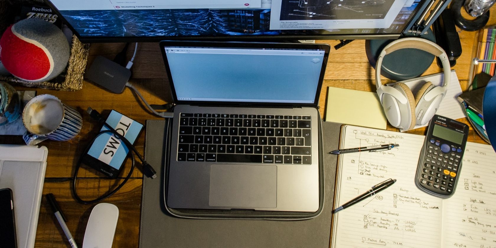 Open Macbook on a cluttered desk.