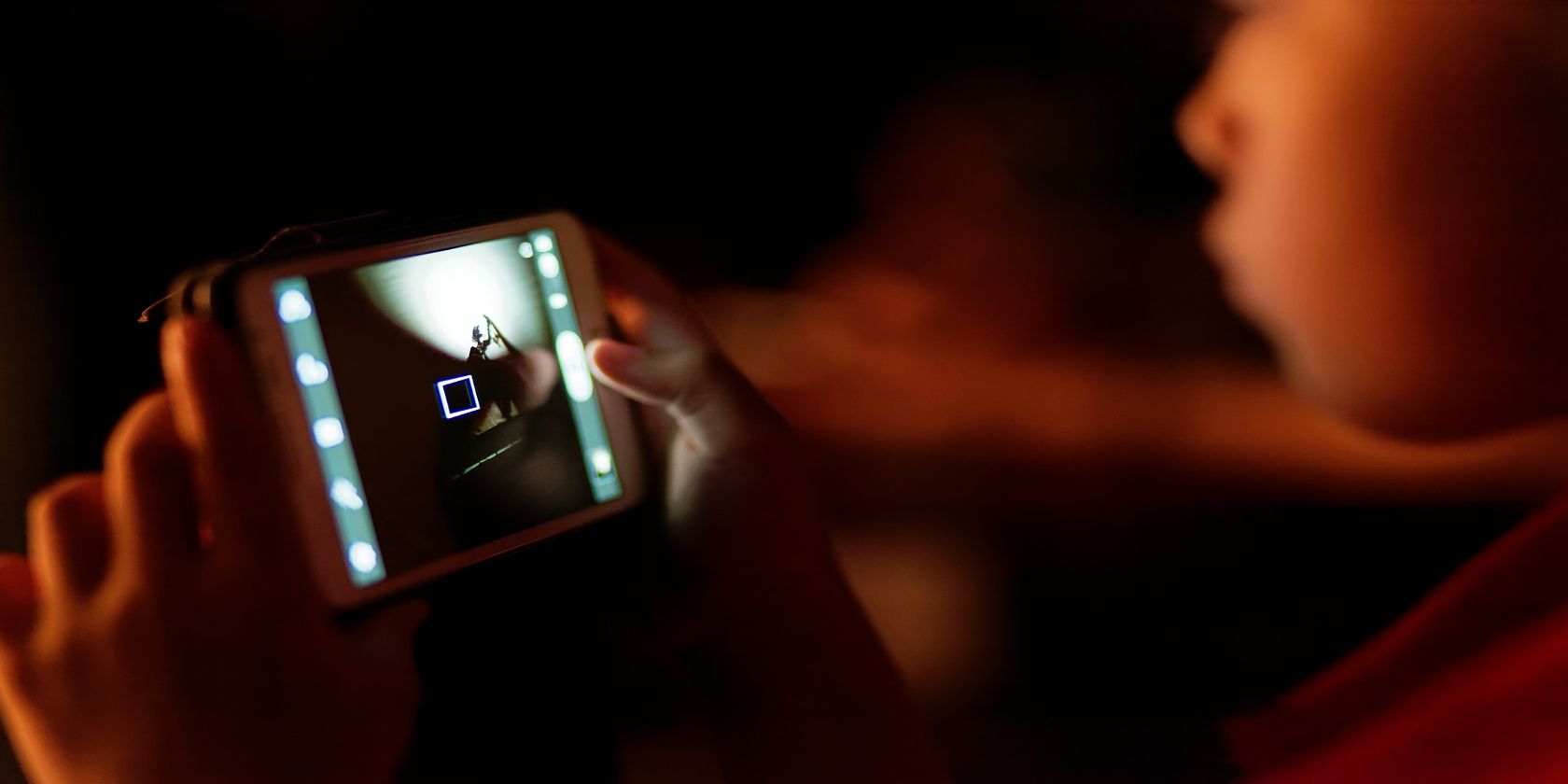 person holding smartphone with dark background