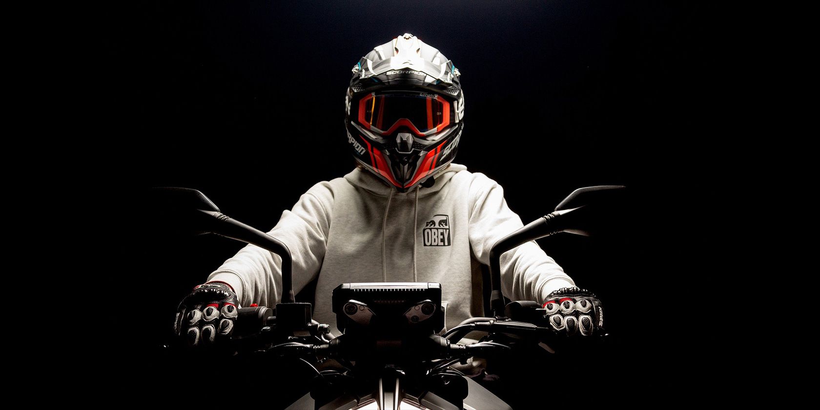 motorcycle rider wearing a smart helmet while seated on his bike with a black background