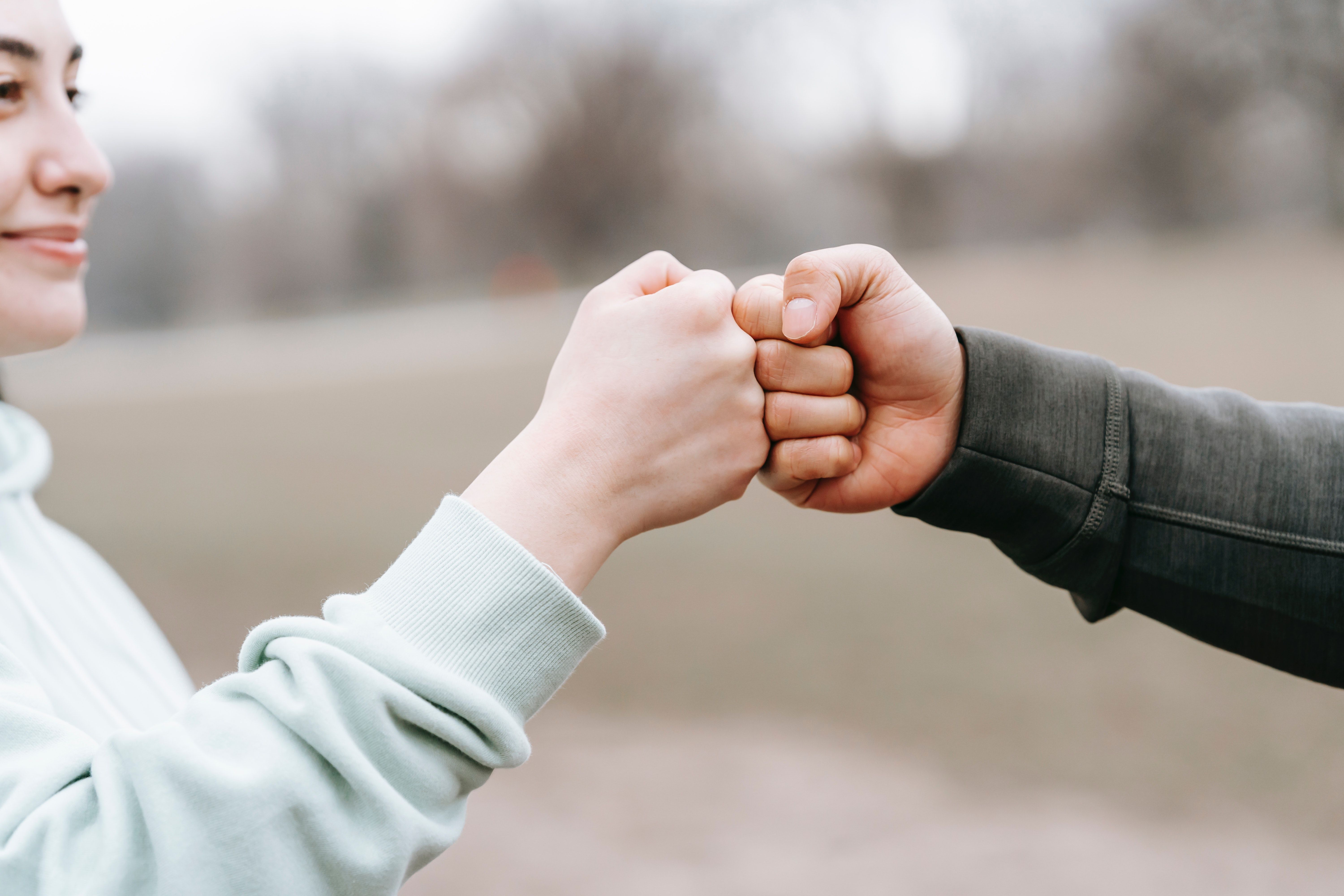 A man and a woman fist bumping each other