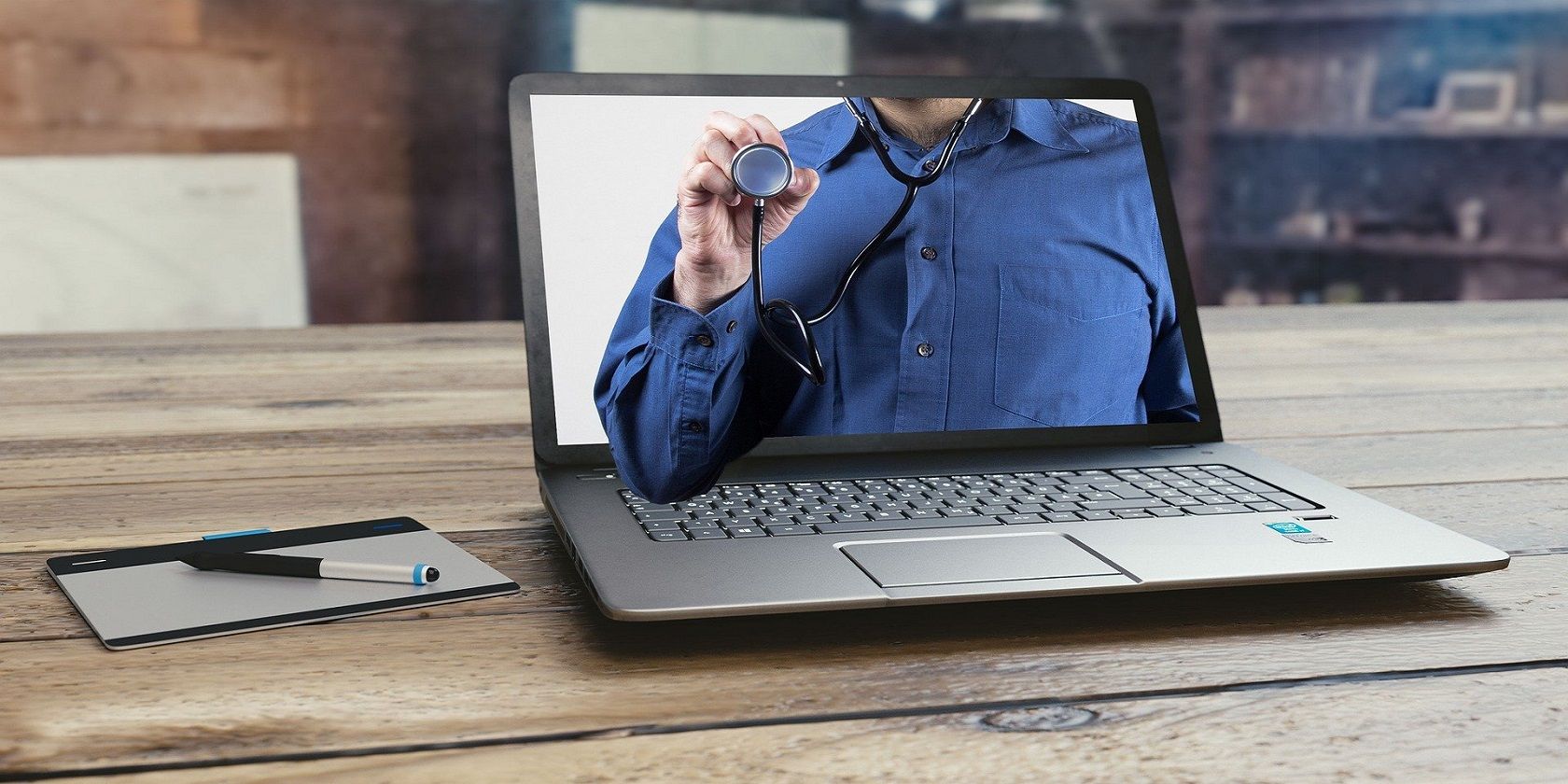 Doctor showing on a laptop, holding a stethoscope 