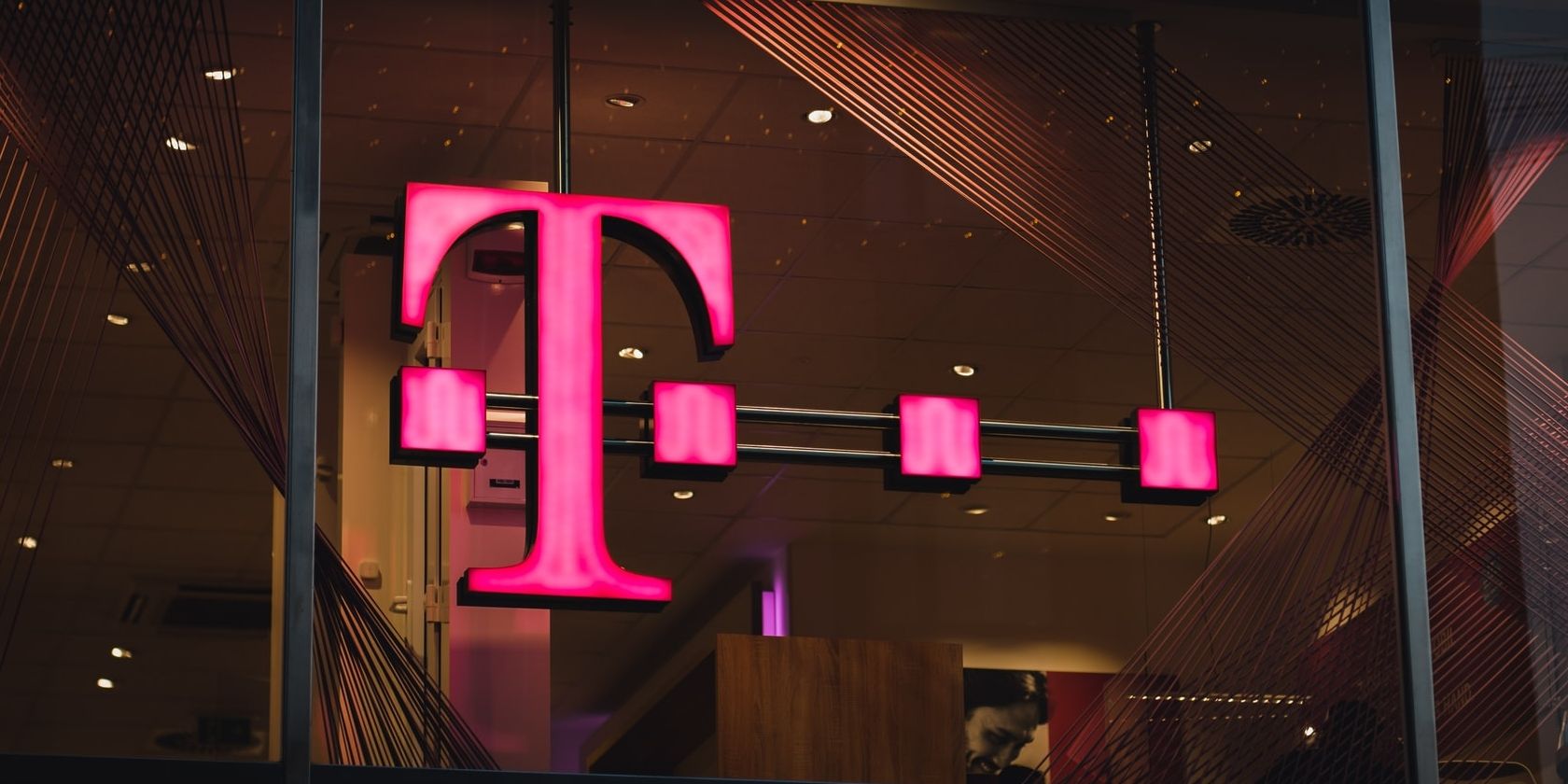 T-Mobile sign lit up in neon pink.