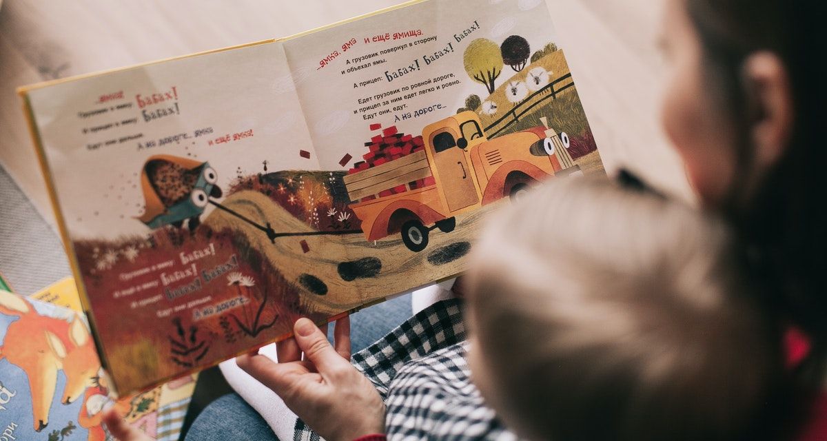 woman reading book with pictures to toddler