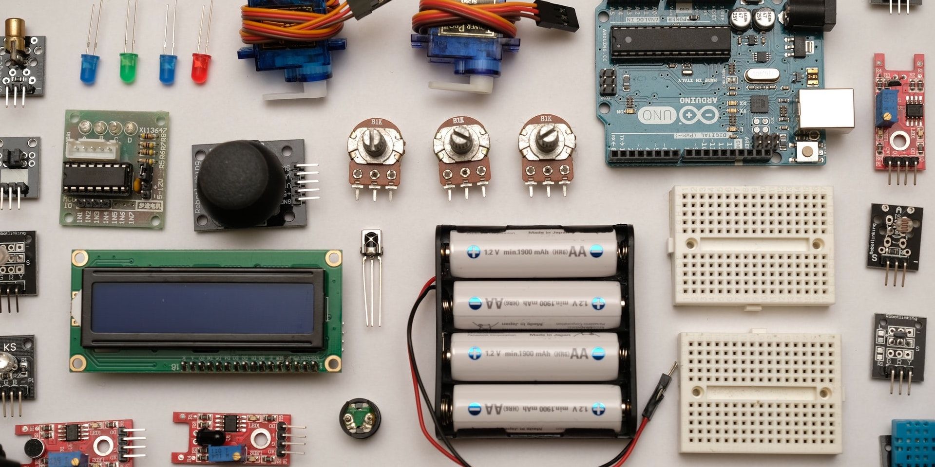 Different types of small electronic parts laid out neatly on a white table