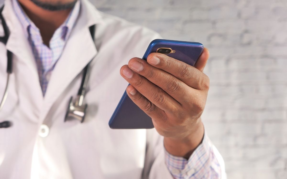 Doctor in white coat using a smartphone