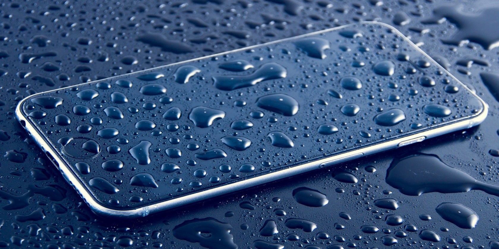 Phone with water drops on dark gray background