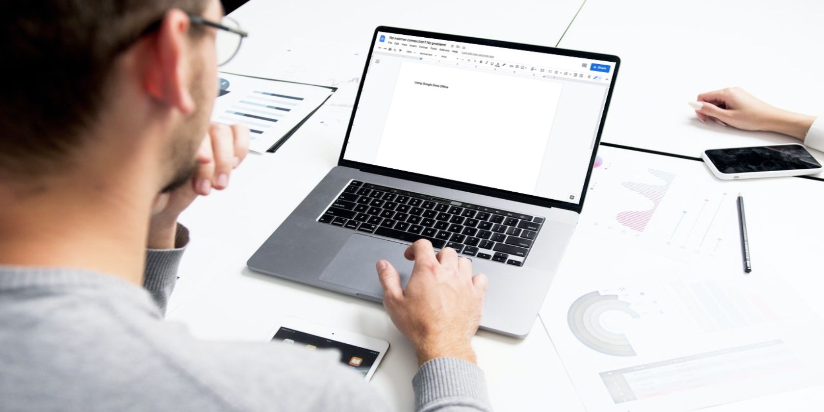 Image shows a man using Google Docs on his laptop