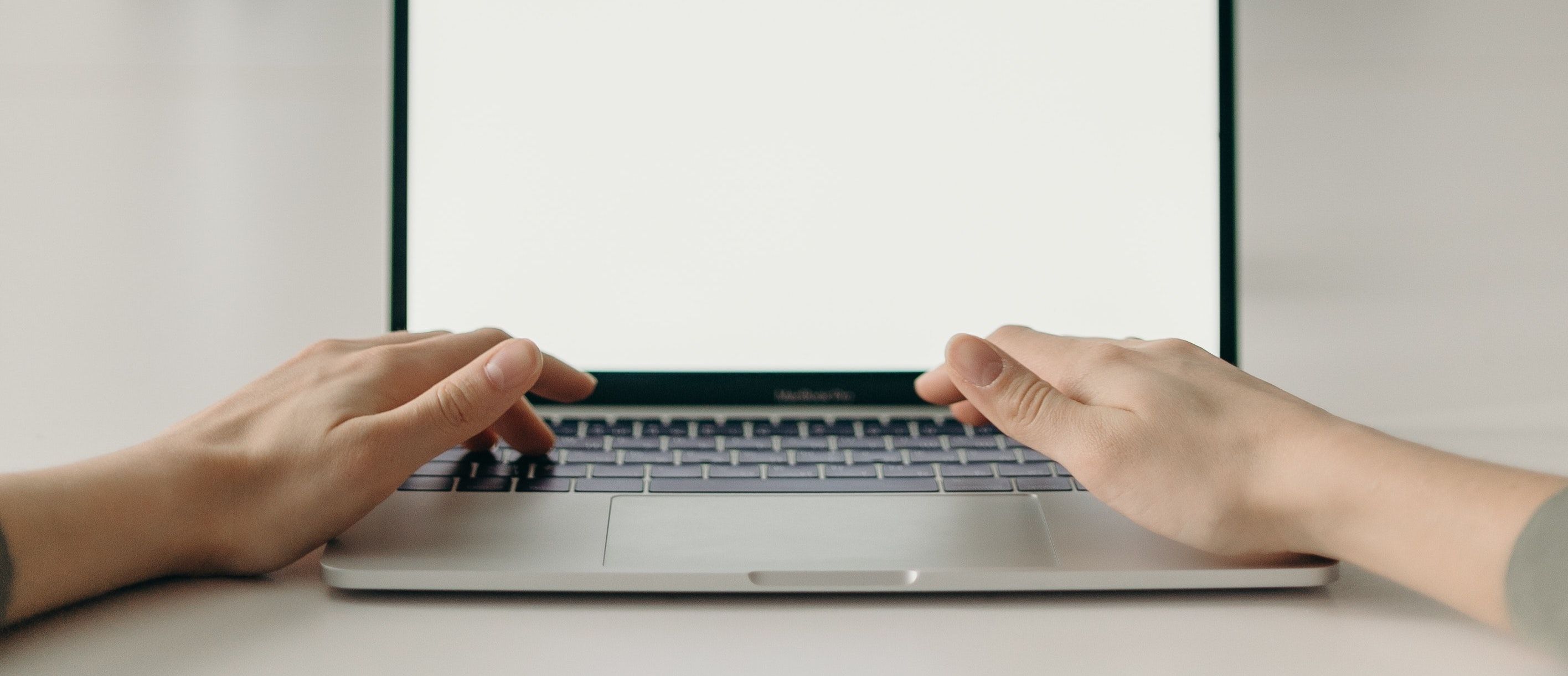 Hands typing on MacBook Pro keyboard