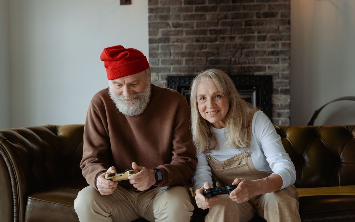 Senior couple playing games on couch